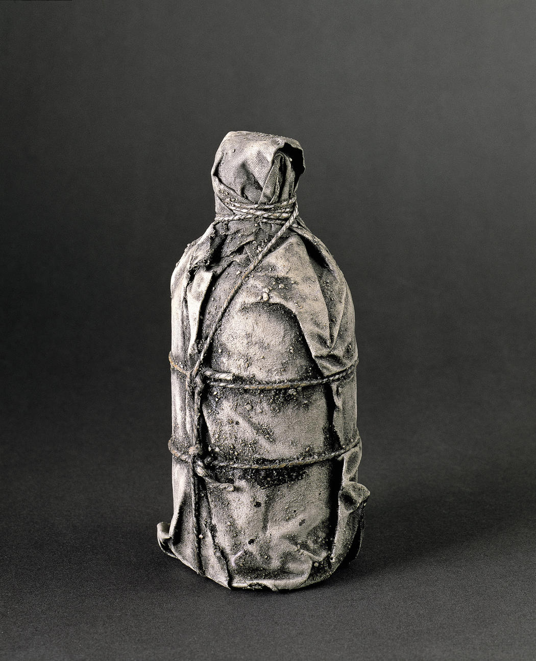 Bottiglia impacchettata (1958; tessuto, corda, lacca, vernice, sabbia, bottiglia; 20,3 x 7,6 cm; Carbondale, Collezione Kimiko e John Powers)