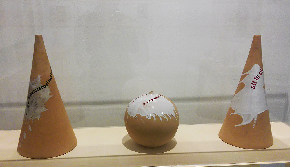 Ugo Carrega, da sinistra a destra: Che il pensiero si faccia (1987; smalti su ceramica, vaso altezza 46 cm, base diametro 23 cm; Collezione Sarenco), La materia è conforme alla mente (1986; smalti su ceramica, vaso sferico altezza 23 cm, diametro 22,5 cm; Collezione Sarenco), All is clear now (1997; smalti su ceramica, vaso altezza 46 cm, base diametro 23 cm; Collezione Berardelli)