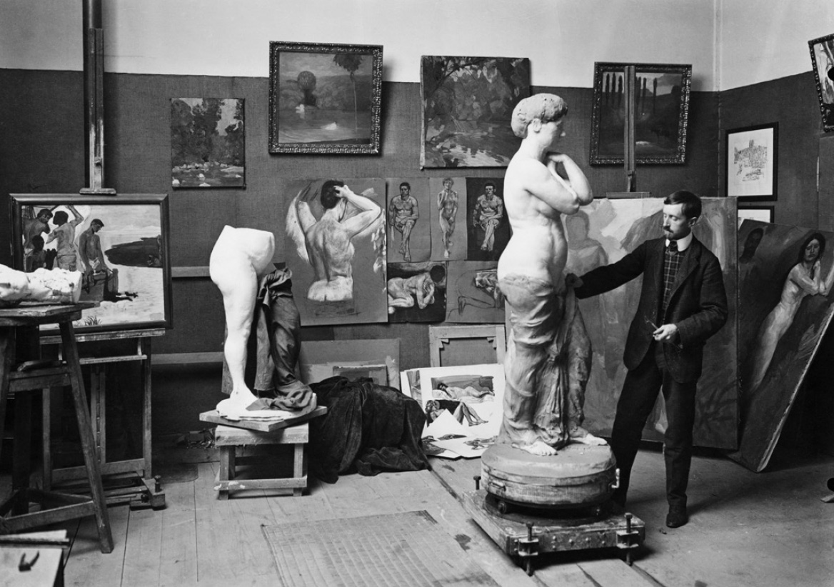 Carl Burckhardt nell'atlelier di Arlesheim accanto al secondo modello in argilla per la Venere. Sullo sfondo i resti del primo modello. Fotografia del 1907. 
