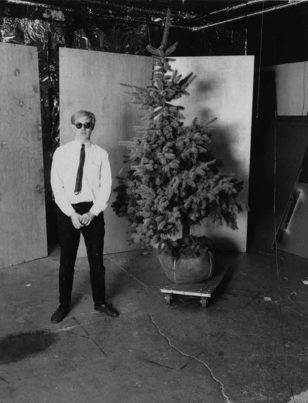 Andy Warhol posa con l'albero di Natale
