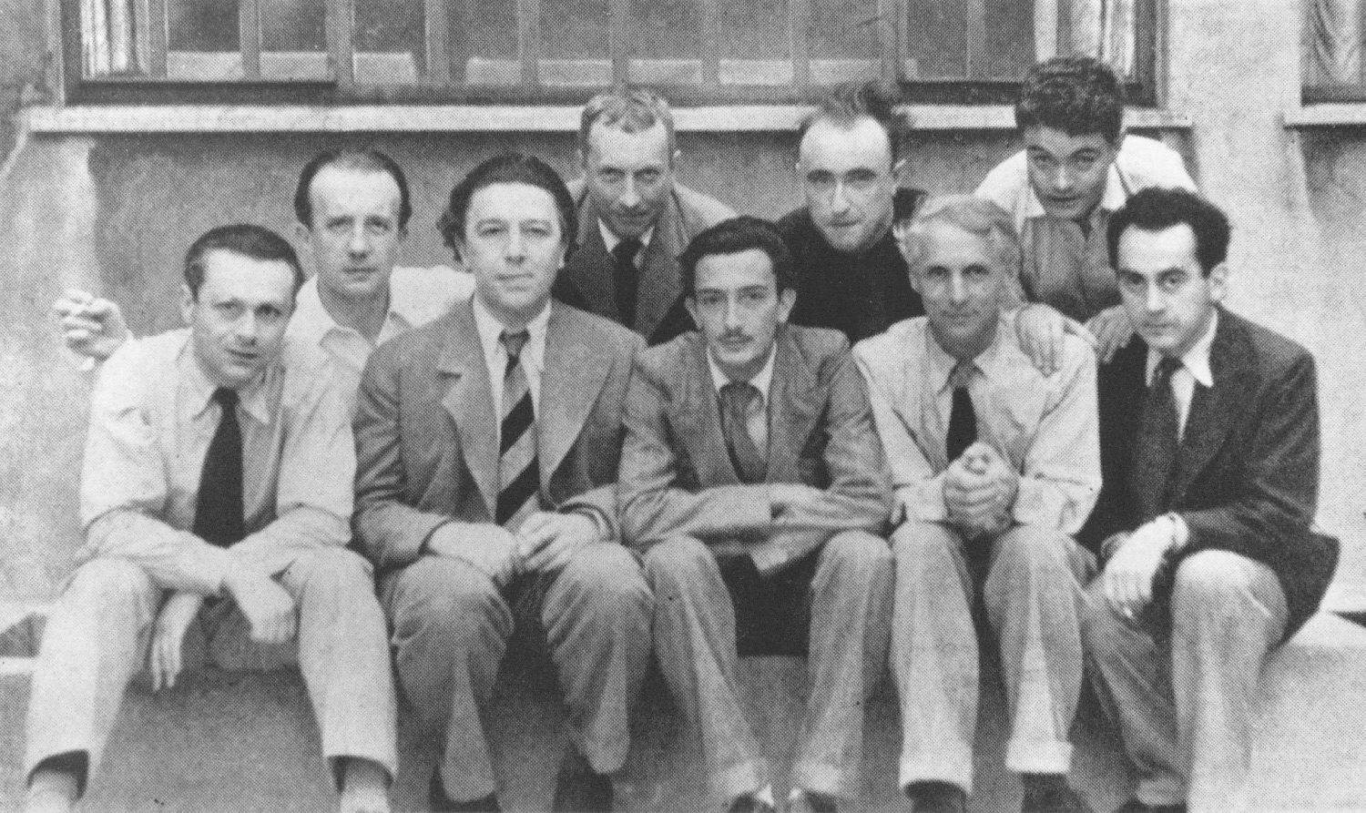 Tristan Tzara, Paul Éluard, André Breton, Hans Arp, Salvador Dalí, Yves Tanguy, Max Ernst, René Crevel, and Man Ray. Paris, ca. 1930. Courtesy Stiftung Arp e.V., Berlin/Rolandswerth 
 Tristan Tzara, Paul Éluard, André Breton, Hans Arp, Salvador Dalí, Yves Tanguy, Max Ernst, René Crevel e Man Ray. Paris, ca. 1930. Courtesy Stiftung Arp e.V., Berlin/Rolandswerth