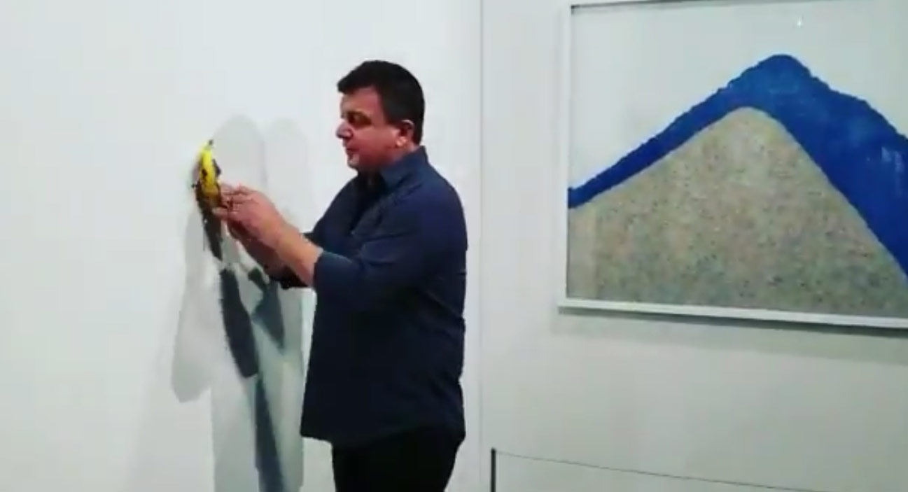 David Datuna stacca la banana di Cattelan prima di mangiarsela