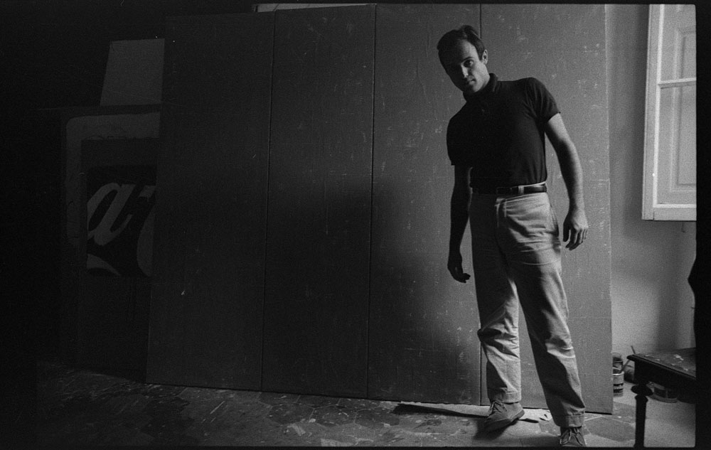 Mario Schifano nel suo studio davanti all’opera Qualcos’altro, Roma, 1962. Courtesy Archivio Mario Schifano. 
 Mario Schifano nel suo studio davanti all’opera Qualcos’altro, Roma, 1962. Courtesy Archivio Mario Schifano.