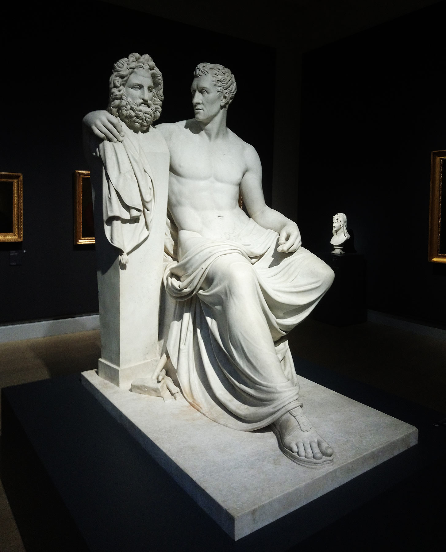 Giovanni Ceccarini, Antonio Canova sedente in atto di abbracciare l'erma fidiaca di Giove (1817 circa - 1820; marmo, 188 x 107 x 155 cm; Frascati, Palazzo Comunale)
