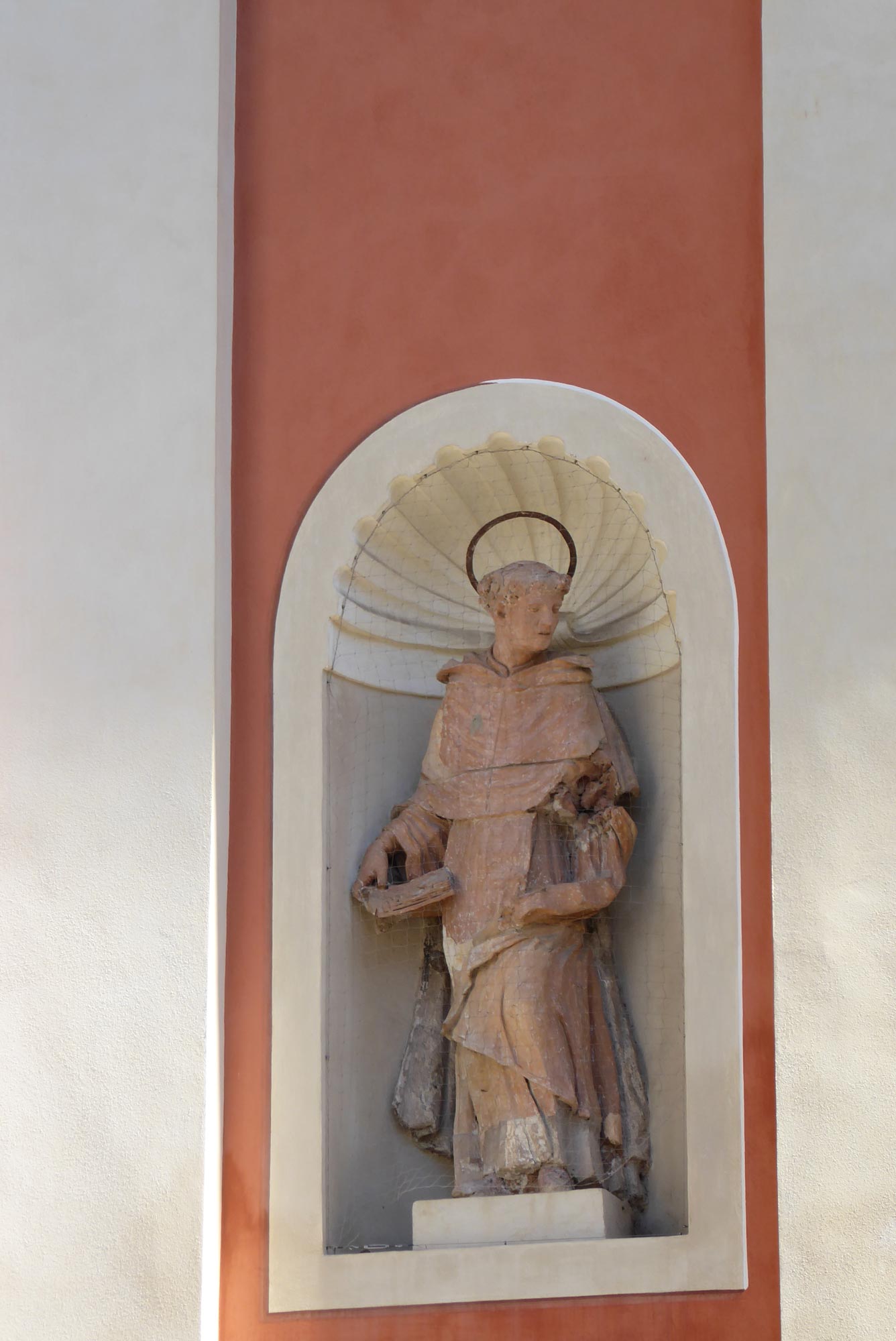 Chiesa domenicana. Le statue in facciata, capolavori della coroplastica emiliana, già dichiarate assai rare dal celebre studioso Giancarlo Boiani, nonostante ripetuti richiami negli anni scorsi hanno continuato a perdere le dita, eppoi le mani, ed ora le braccia e altre parti minori. Col libro in mano qui vediamo la statua di San Pietro Martire,  che Boiani pubblicò integra nel 1980. 
