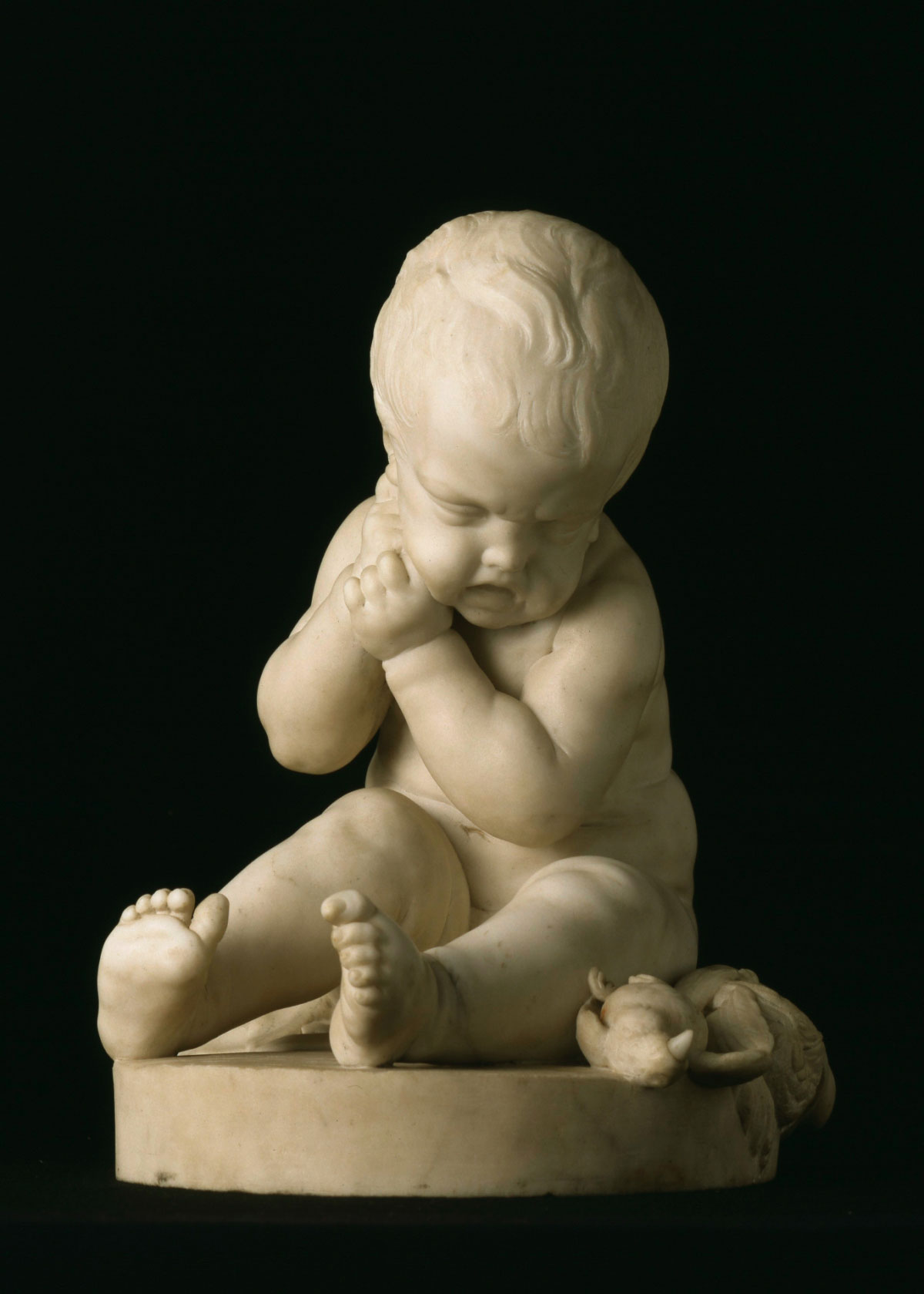 Jean-Baptiste Pigalle, Statuetta di un bambino (XVIII secolo; marmo, 42,5 x 35,5 x 37,5 cm; Lisbona, Museo Gulbenkian)

