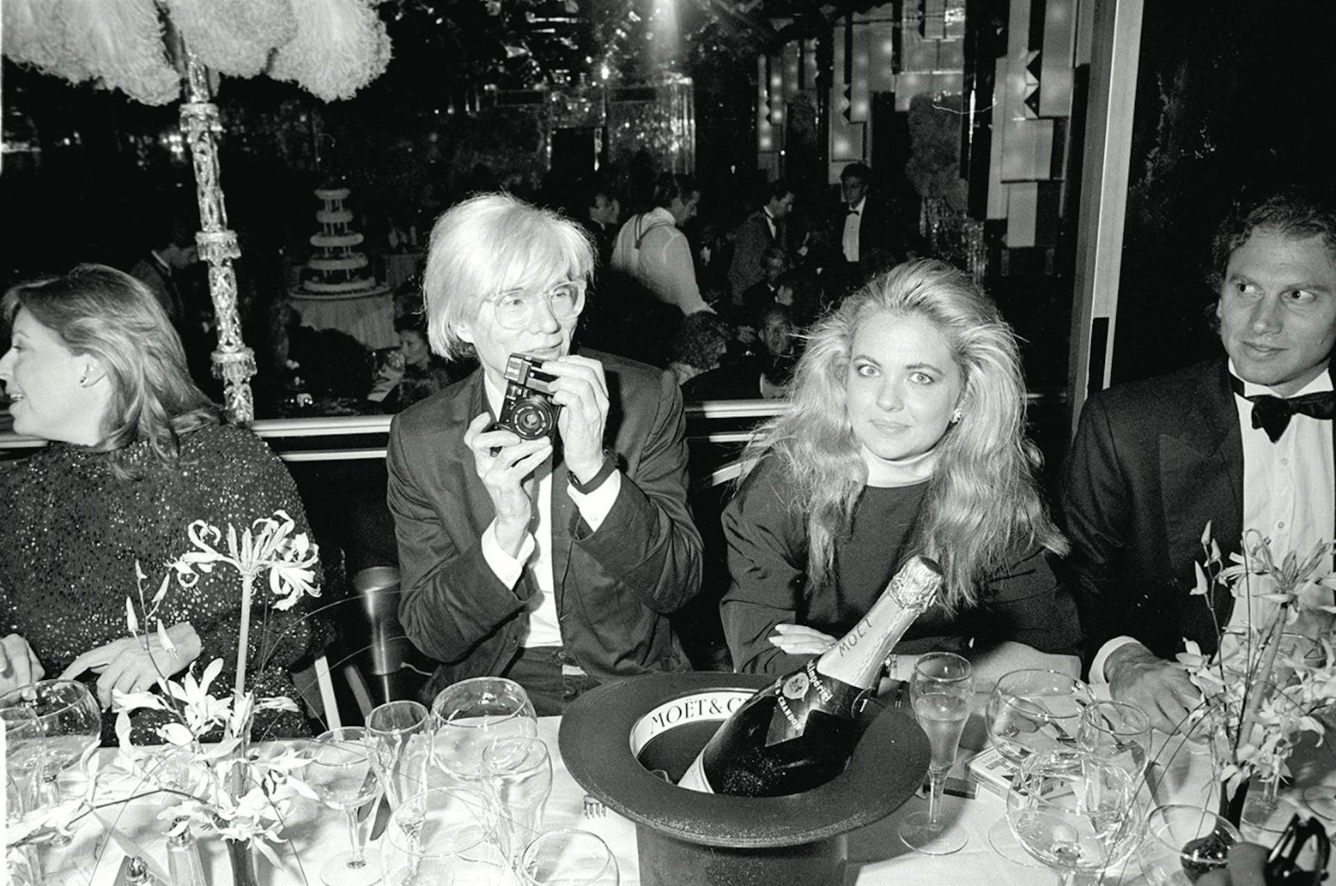 Andy Warhol a una festa con, in bella vista, una bottiglia di Moët & Chandon
