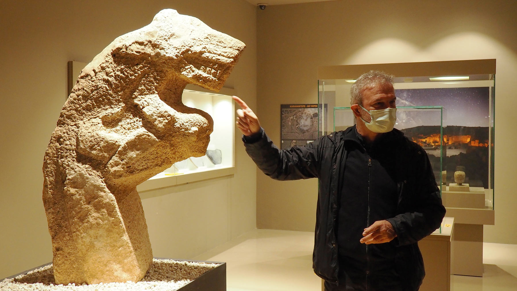 Il professor Nemci Karul, direttore degli scavi a Karahan Tepe, accanto a una scultura rinvenuta nel sito e conservata al Museo Archeologico di Şanlıurfa. Foto di Michela Bassanello
