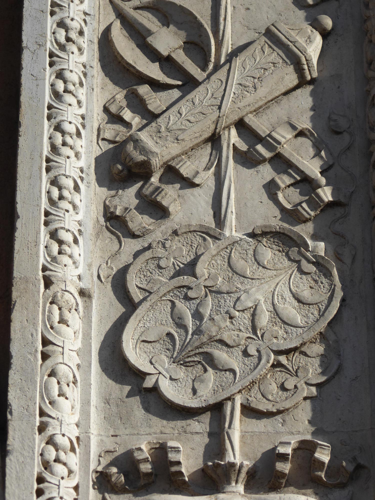 Detalle.  La aljaba entrelazada con el bipennis y los escudos auxiliares tutelares.