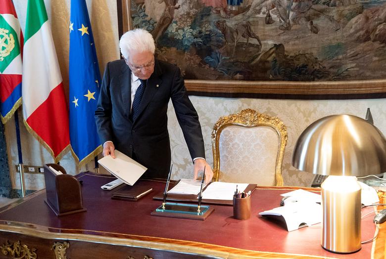 President of the Republic Sergio Mattarella at his desk, holding an Atollo lamp. Photo: Paolo Giandotti/Press Office of the Quirinale