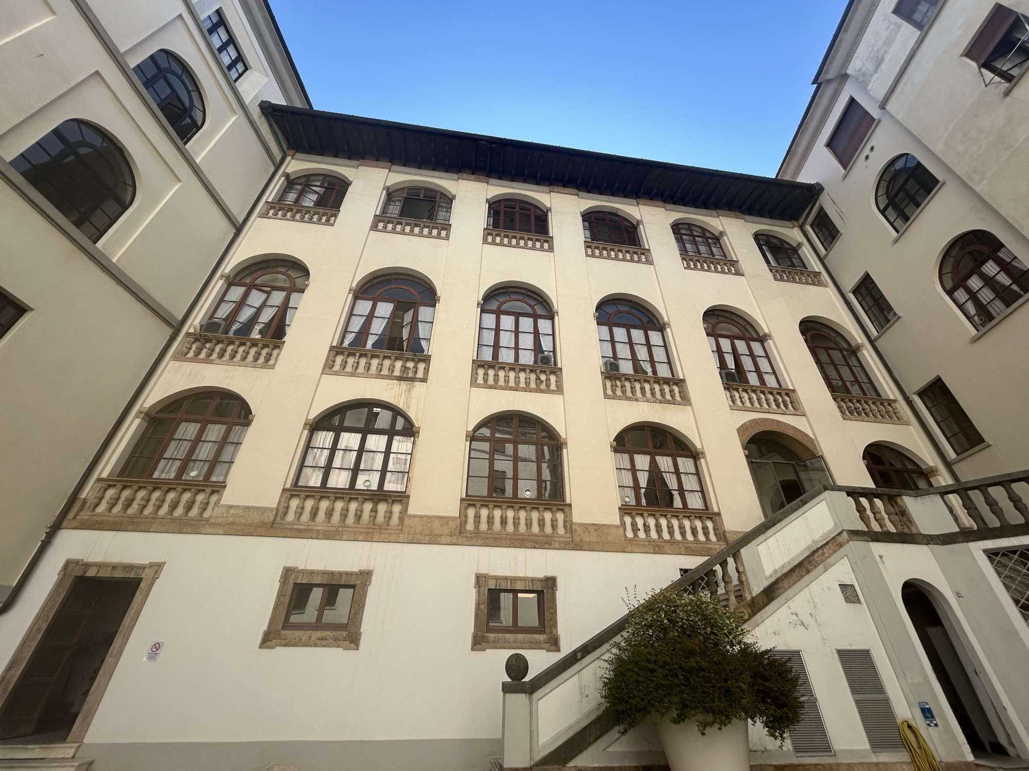The rear facade as seen from the inner courtyard, and carved out from the closure of the loggia. Photo: Jacopo Suggi