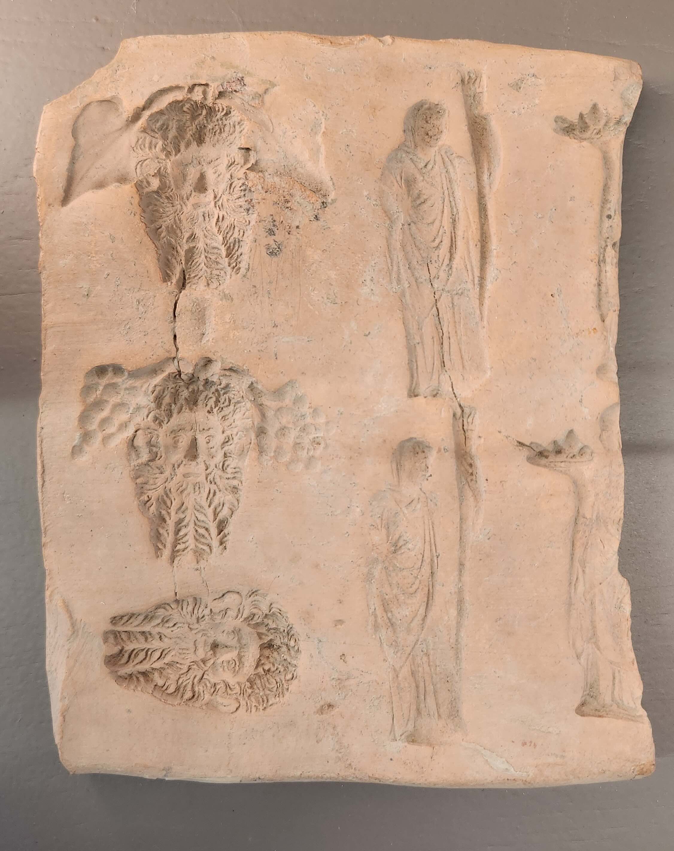 Matriz de placa con máscaras y figuras de pie. Colección Gamurrini © MiC- Dirección Regional Museos Nacionales Toscana