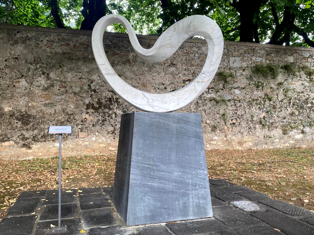 Junkyu Muto, Der Windkreis (2003; Marmor, 125 x 158 x 40 cm, Sockel 120 x 98 x 98 cm; Pietrasanta, Piazza Statuto)