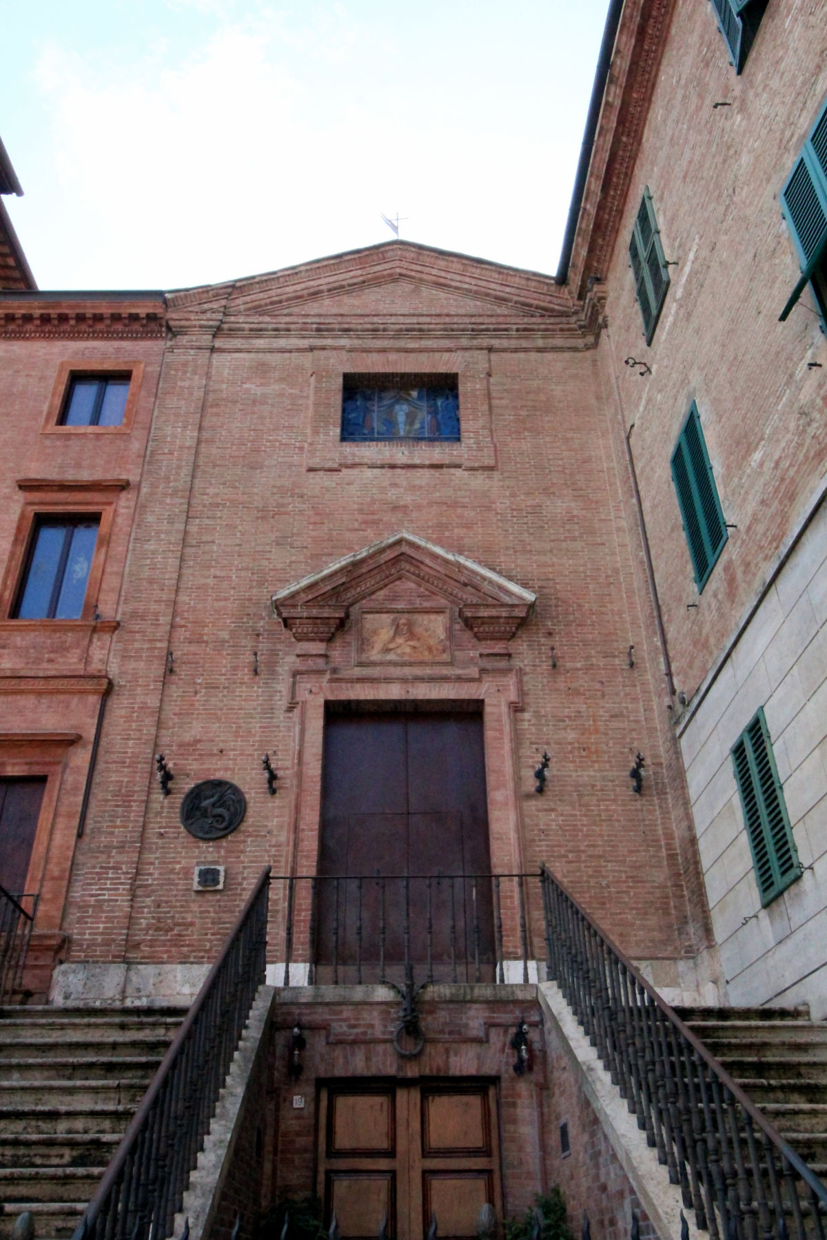 Museo Contrada del Drago Siena - Medaillon mit einem Drachen am Eingang der Kirche Santa Caterina auf der Piazza Matteotti, Ecke Via del Paradiso, Siena. Foto: Wikimedia Commons - LigaDue